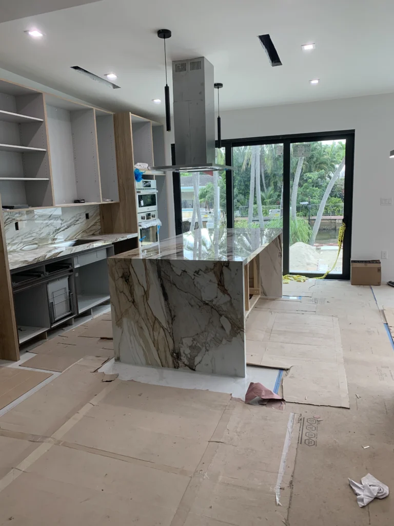 A kitchen with marble counter tops and a large island.
