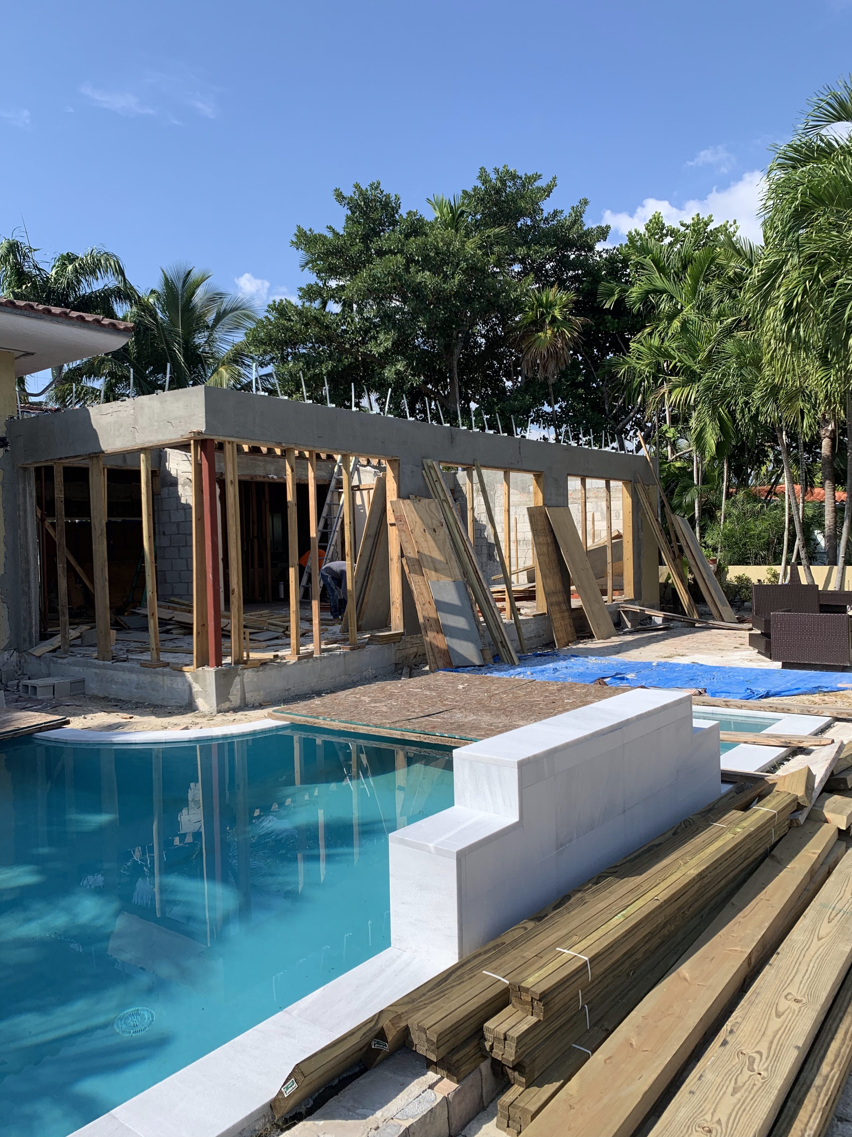 IMG_7896 A pool with a wooden deck and a building